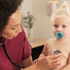 Kinderkrankenschwester horcht die Brust eines Säuglings mit einem 3M Littmann Cardiology III Stethoskop ab. 